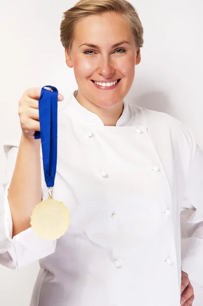 Woman in chef outfit and first prize medal smiling. over white b — Stock Photo, Image