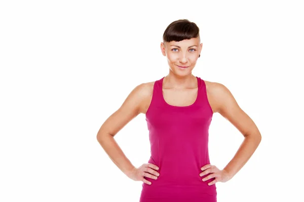 Jonge vrouw in fitness outfit met glimlach op witte achtergrond. — Stockfoto