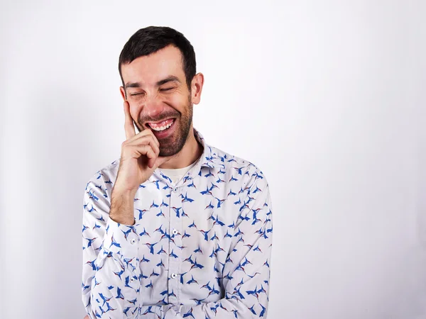 Man lachen over witte achtergrond in moderne mode shirt. — Stockfoto