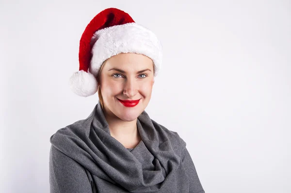 Vrouw in KERSTMUTS glimlachen op witte achtergrond. Stockfoto