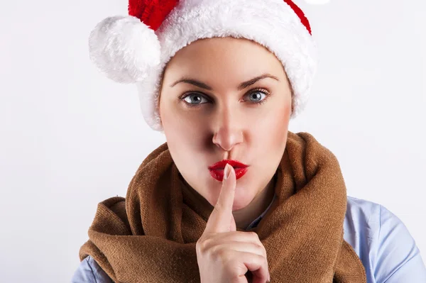 Feliz Navidad chica en Santa Sombrero haciendo un signo de silencio —  Fotos de Stock