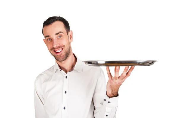 Bonito garçom segurando uma bandeja de prata vazia, isolado em branco — Fotografia de Stock