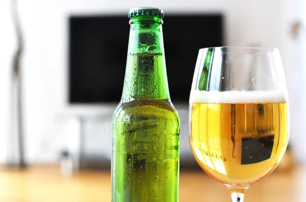 Glas bier over Tv-toestel — Stockfoto