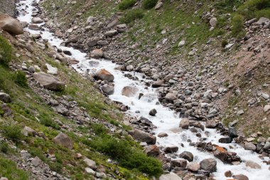 Büyük kayaların üzerinden dağ nehir akar.