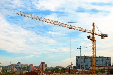 Mavi gökyüzü arka planında sarı inşaat vinci