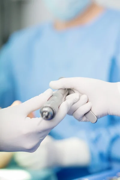 Close-up of scrub nurse taking medical instruments for operation — Stock Photo, Image