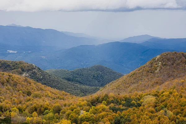 Autumn picture from Spanish mountain Montseny, near Santa fe del Montseny, Catalonia. In the distance, a shower is approaching,