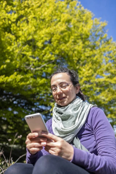 美しい 森の中で遠足の若いスペイン人女性 携帯電話を使用してください — ストック写真