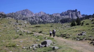 Güneşli bir günde İspanyol Pirenesi Dağı 'nda yürüyen turistler.