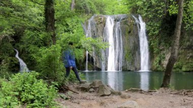 İspanya 'da, Katalonya' nın Rupit köyünden güzel bir şelalenin yanında yürüyen turist kadın.