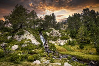 Pirenes Dağı 'ndaki La Cerdanya' da küçük bir dereyle gün batımı manzarası, Katalonya, İspanya.