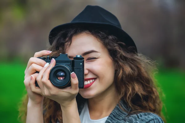 Menina de chapéu sorrindo e fotografando a natureza . — Fotografia de Stock