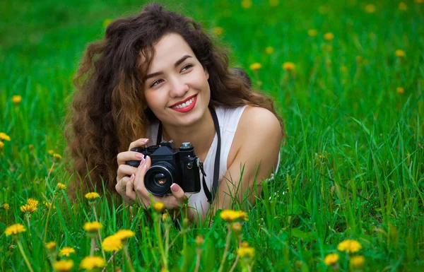 Piękne dziewczyny fotograf z kręconymi włosami trzymając aparat fotograficzny a — Zdjęcie stockowe