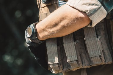 Kurşun geçirmez yelek ve kısa kollu tişört giyen erkek asker. El saatler.