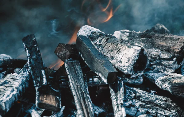 A madeira cortada queima e fuma na grelha. Preparando-se para assar carne no fogo. Churrasco na natureza . — Fotografia de Stock