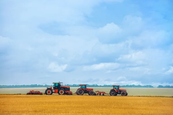 Jour d'été trois tracteur avec charrue debout sur le champ de blé en pente avant le début des travaux. Préparation des terres avant plantation . — Photo