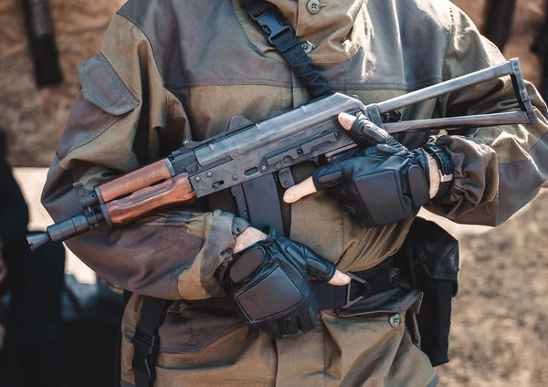 Soldado en guantes de camuflaje y sosteniendo un arma . — Foto de Stock