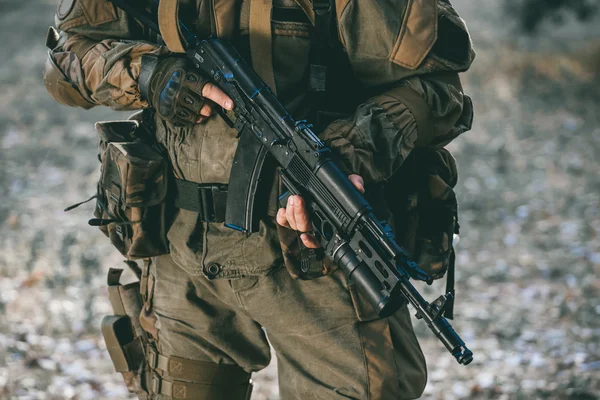 Askeri kamuflaj ve koruyucu eldiven silah doğrultmak görevlerin performans. Savaş alanı. — Stok fotoğraf