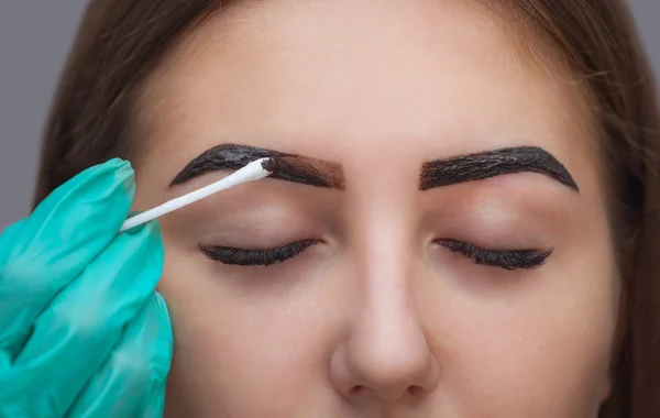 Master korrigiert Make-up, Form und Farbe der Augenbrauen Henna gibt es in einem Schönheitssalon, Spa. Professionelle Hautpflege. — Stockfoto