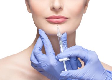 Doktor kozmetik uzmanı güzellik salonundaki güzel bir kadının dudaklarına botoks yapıyor. Kozmetoloji cilt bakımı..
