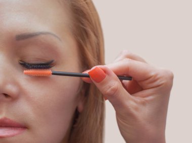 Güzellik salonunda uzun kirpikleri olan güzel bir kadın. Kirpik uzatma prosedürü. Kırbaçlar yakın.