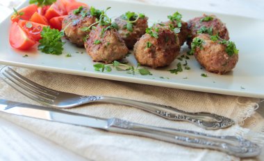 Bir plaka üzerinde taze otlar ile köfte