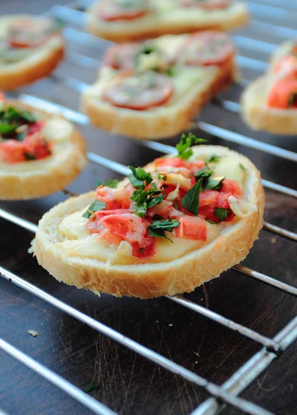 Bruschetta crujiente con tomate, queso y hierbas —  Fotos de Stock