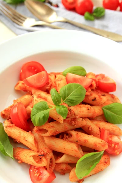 Massa Penne com molho de tomate e folhas de manjericão — Fotografia de Stock