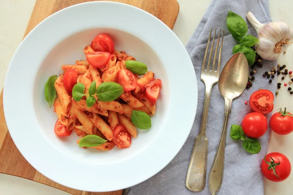 Massa Penne com molho de tomate e folhas de manjericão — Fotografia de Stock