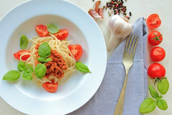 Espaguete com carne e molho de bolonhesa com folhas de tomate fresco e manjericão Fotos De Bancos De Imagens Sem Royalties