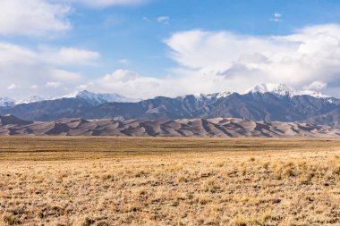 Colorado 'daki Great Sand Dunes Ulusal Parkı' nın dağları ve kumulları görünüyor.