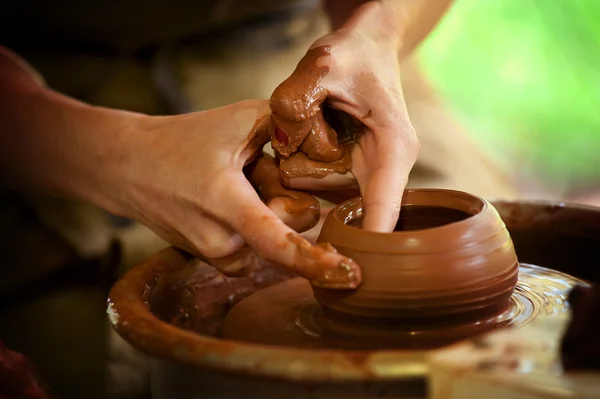 The potter\'s wheel and hands of a potter