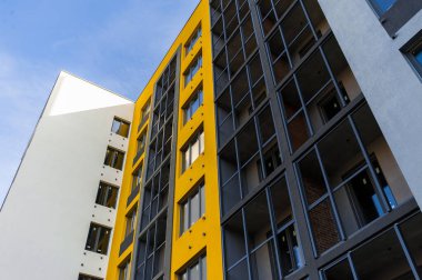 Yeni sarı modern bir binanın ön cephesinin bir parçası.