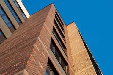 Mavi gökyüzüne karşı modern bir evin tuğla cephesinin bir parçası.