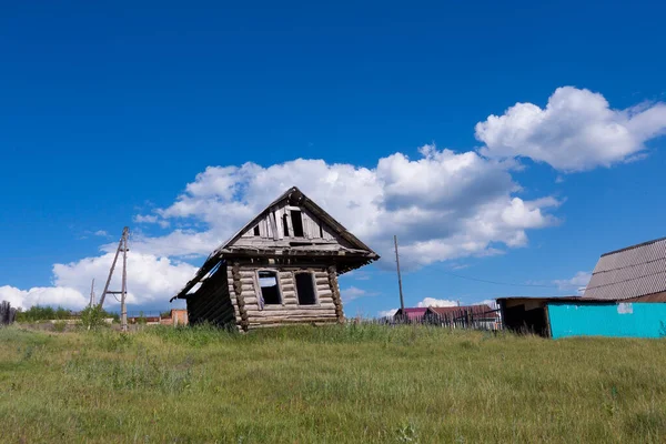 old ruined wooden house against the sky