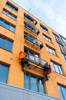 İşçiler inşaat halindeki eve klima taktırıyorlar.