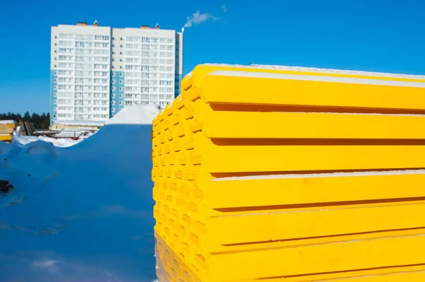 yellow wooden pallet for monolithic construction on the blue sky on the background of a new house