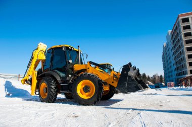 Yeni sarı kazıcı mavi gökyüzüne karşı duruyor.