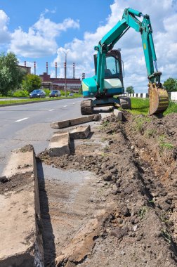 Kazıcı bir çukur kazıyor. yol çalışmaları