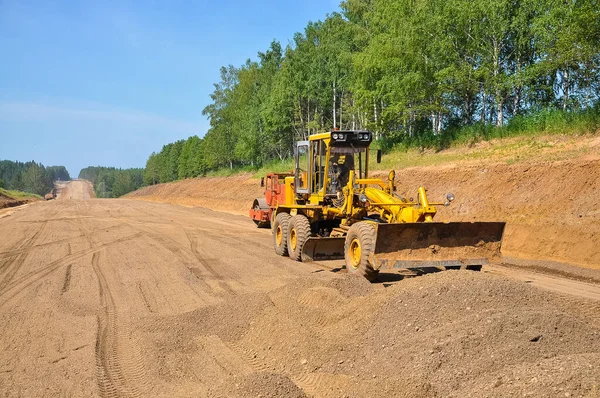 tractor scraper levels the ground of a new road