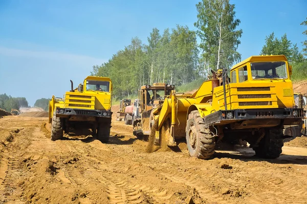 Raschietto Trattore Giallo Livella Terreno Una Nuova Strada Estate — Foto Stock