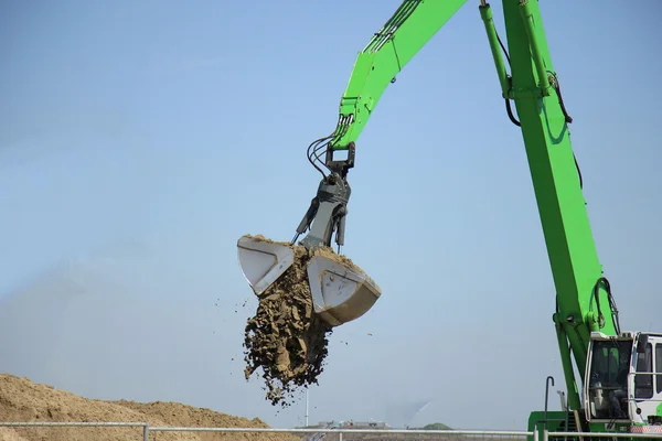 Een groene graafmachine — Stockfoto