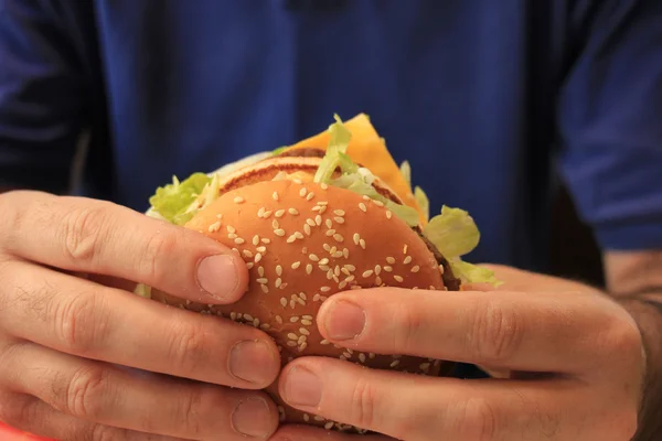 Man holding hamburger — Stock Photo, Image