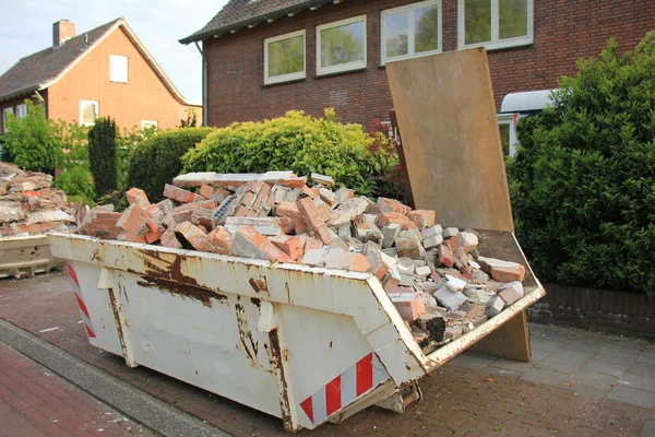 Geladen dumpster in de buurt van een bouwplaats — Stockfoto