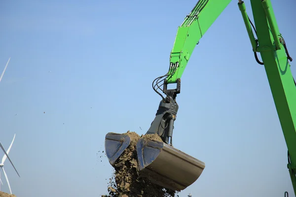 Groene graafmachine opscheppen van zand — Stockfoto