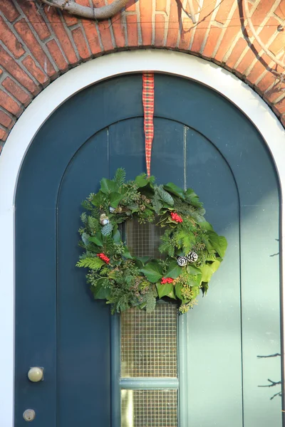 Classic christmas wreath with decorations on a door — Stock Photo, Image