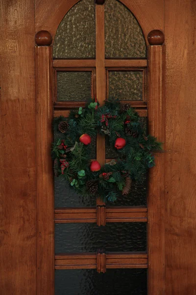 Classic christmas wreath with decorations on a door — Stock Photo, Image