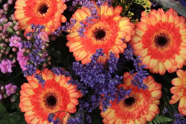 オレンジのガーベラと紫の花 結婚式の花の配置 — ストック写真