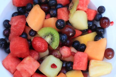 Parlak renklerde taze meyve salatası, taze nane yapraklarıyla süslenmiş.