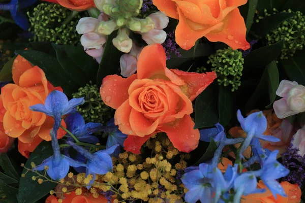 婚礼上的橙色和蓝色花朵安排 橙色玫瑰和蓝色云雀 — 图库照片